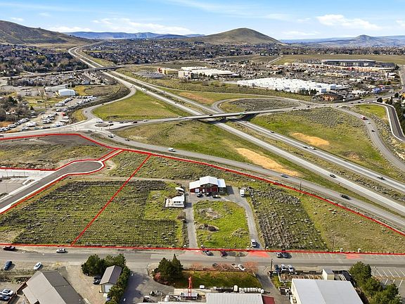 Aerial showing the parcel outlined in red against the Queensgate freeway interchange, with the Horse Heaven Hills and Richland retail corridor visible in the background