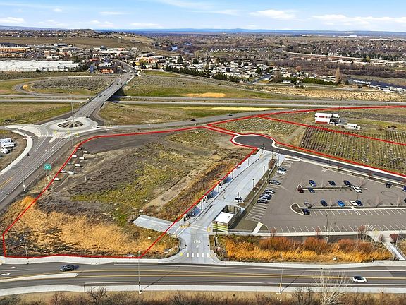 Aerial showing the Queensgate roundabout, the new Ben Franklin Transit transfer station beside the parcel, and the Columbia River with surrounding suburban Richland in the background